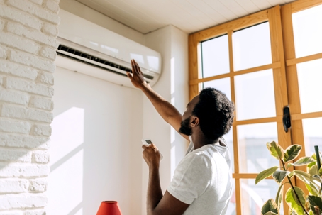 person turning on ductless mini split system